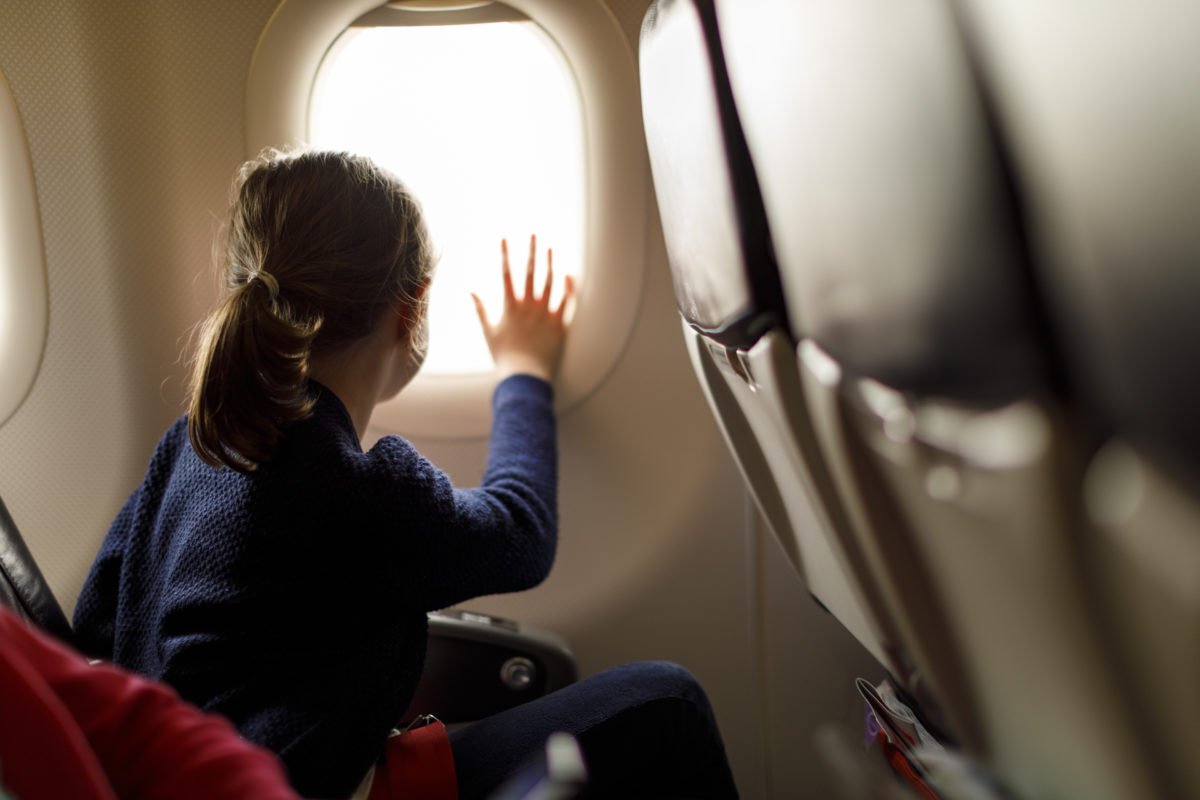 kid looking out airplane window
